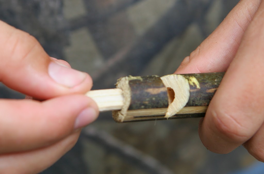 carving the reed for a wooden whistle