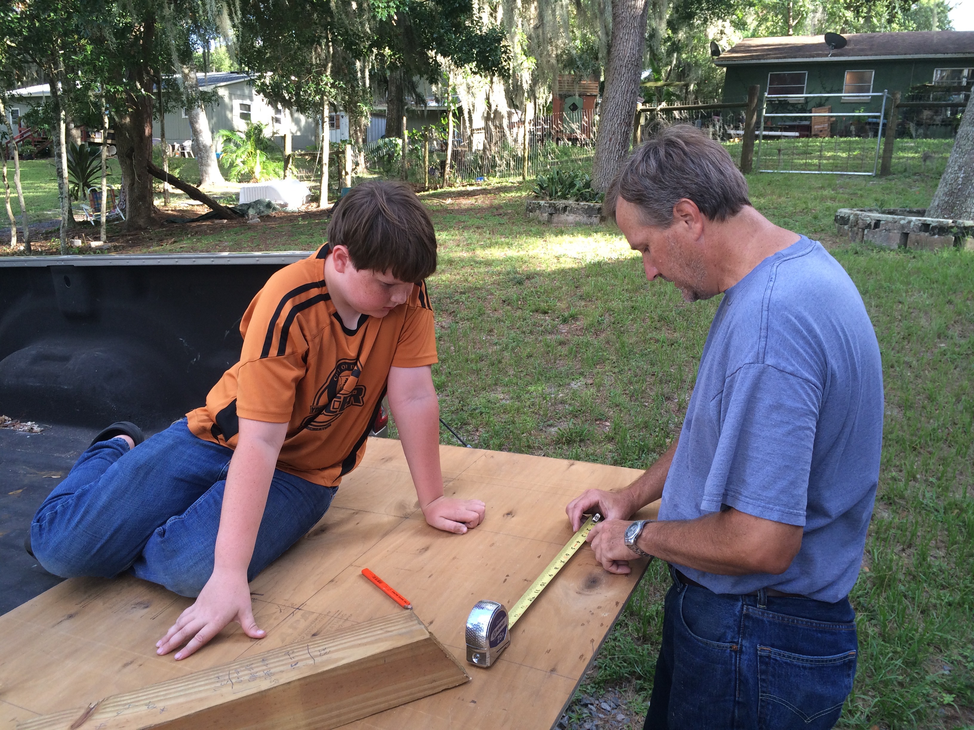 grant and his dad measuring wood for the camper